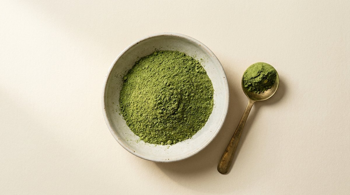 Fine green kratom powder in a ceramic bowl with scoop